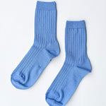 Pair of blue socks on a light gray background