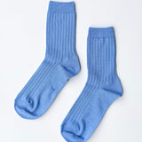 Pair of blue socks on a light gray background