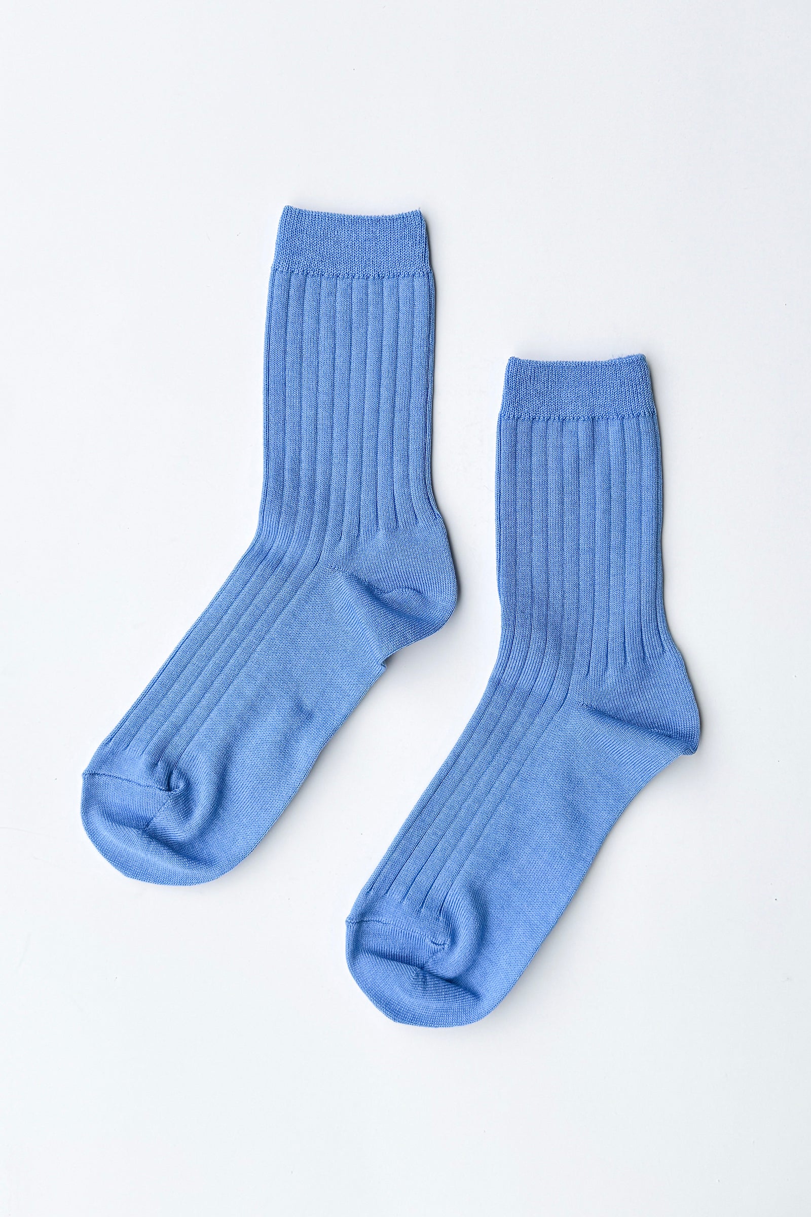Pair of blue socks on a light gray background