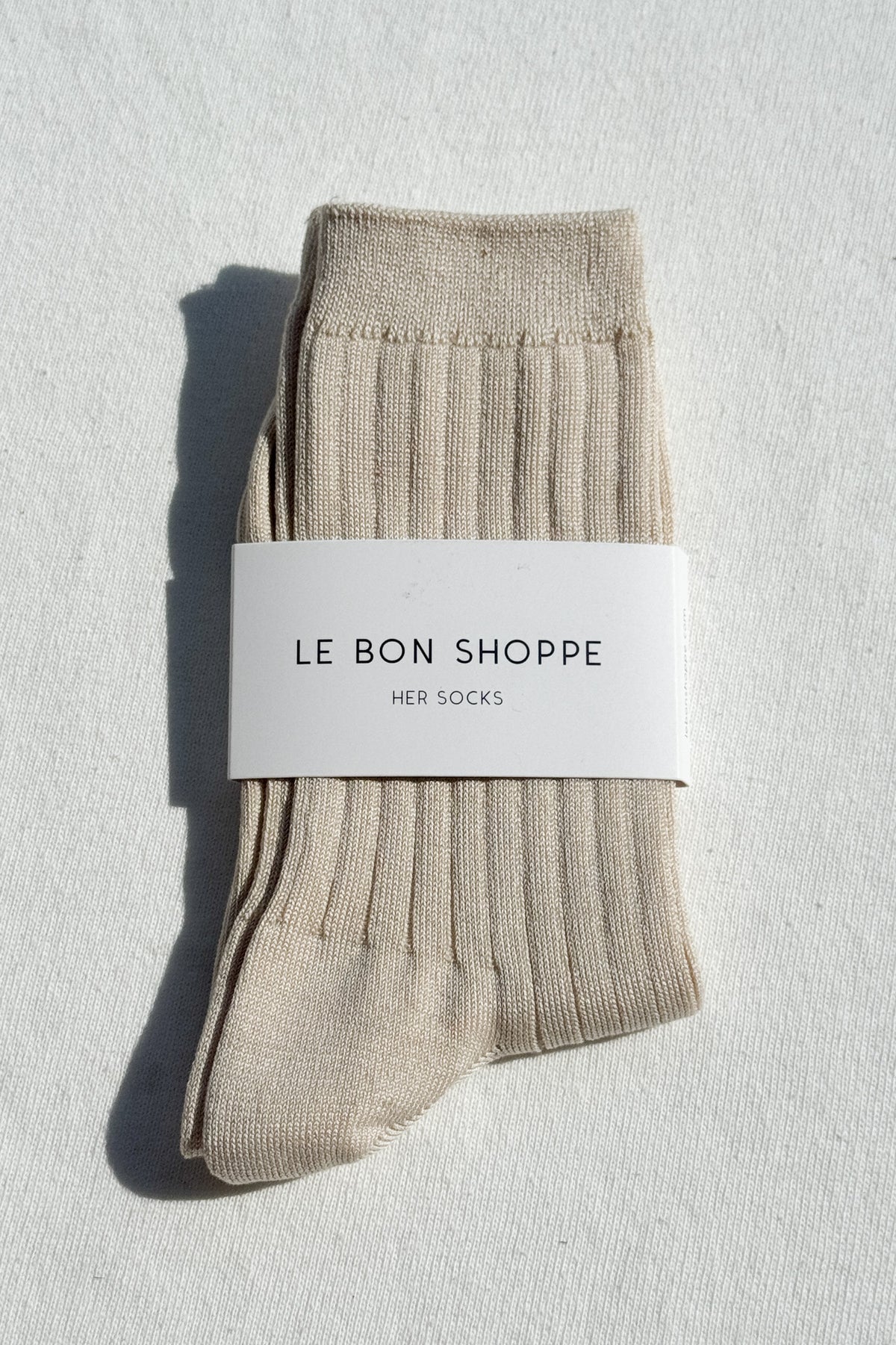 Beige socks with a 'Le Bon Shoppe' label on a light gray background