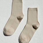 Pair of beige socks on a light gray background