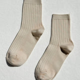 Pair of beige socks on a light gray background