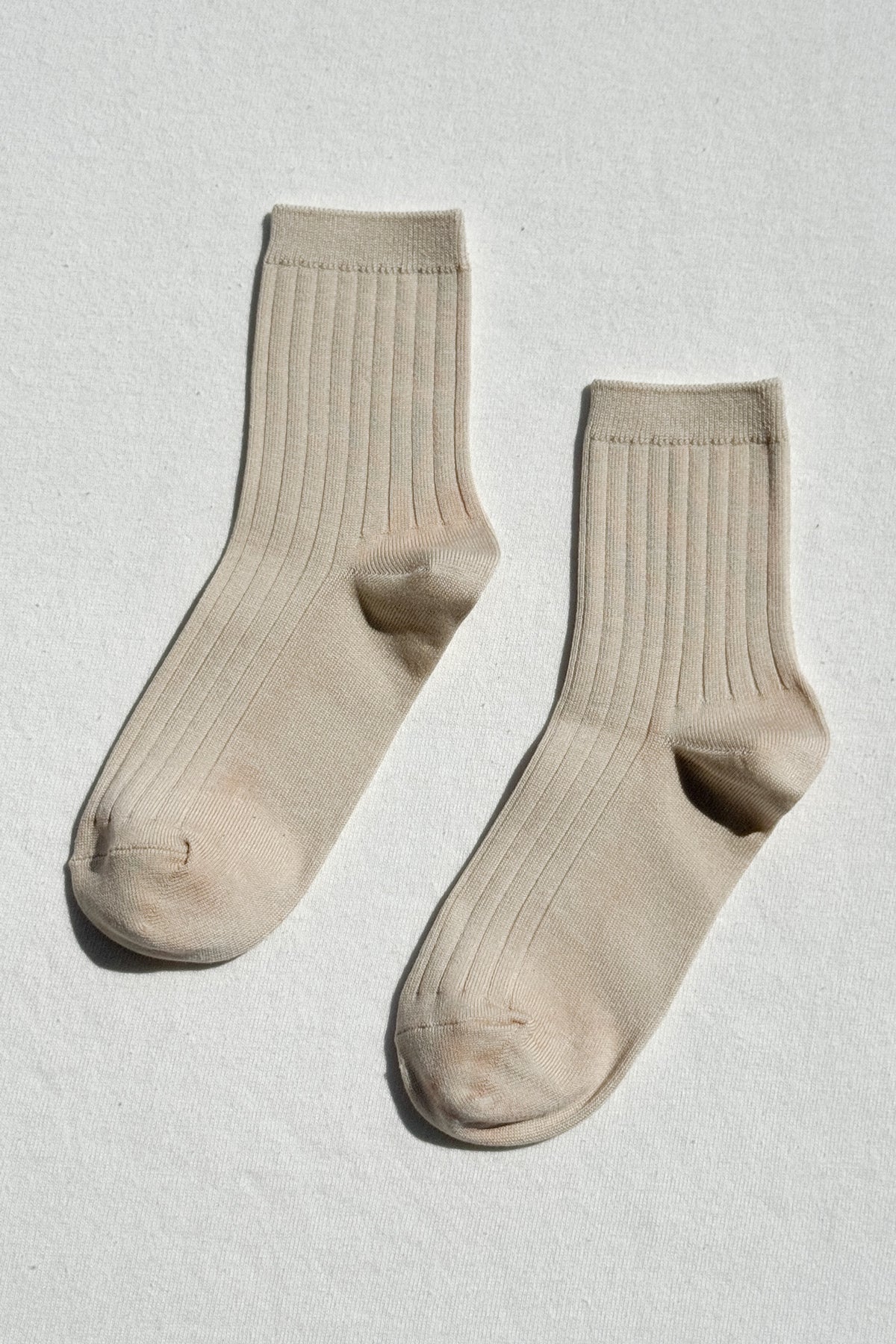 Pair of beige socks on a light gray background