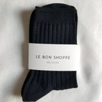 Black sock with a white label on a light gray background