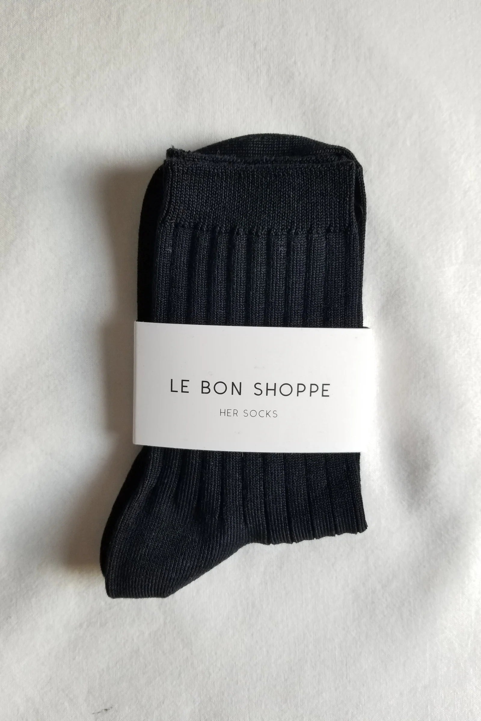 Black sock with a white label on a light gray background