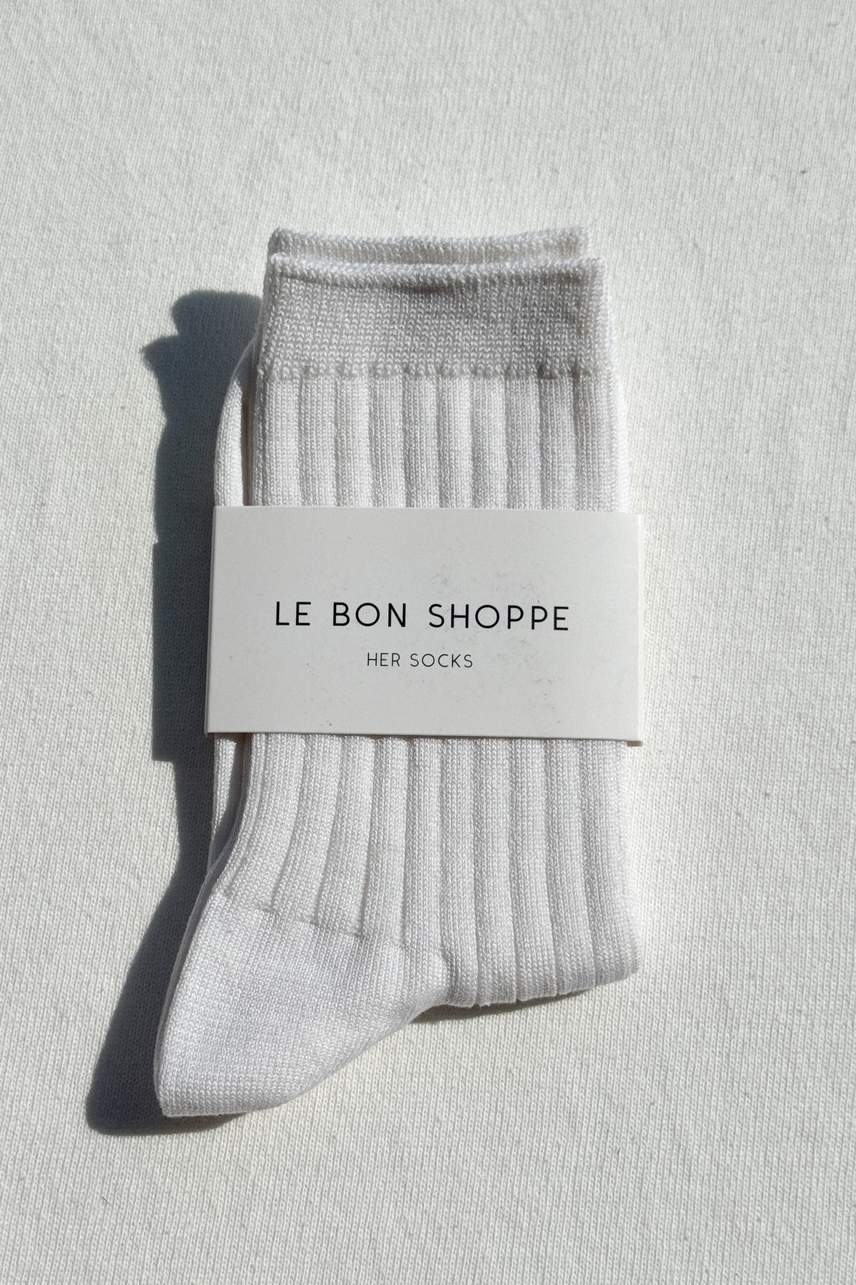 Gray socks with a 'Le Bon Shoppe' label on a light gray background