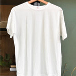 White tee shirt on a woo hanger on a cabinet