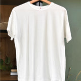 White tee shirt on a woo hanger on a cabinet
