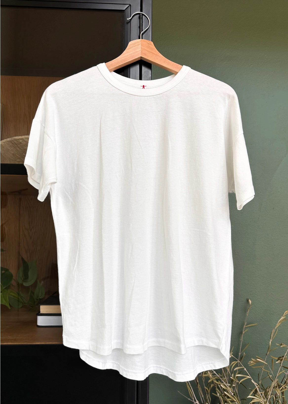 White tee shirt on a woo hanger on a cabinet