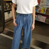 Person wearing white tee shirt, jeans and yellow shoes in a book store