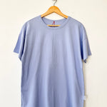 Light blue t-shirt on a wooden hanger against a white background