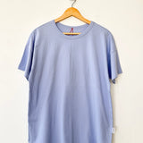Light blue t-shirt on a wooden hanger against a white background