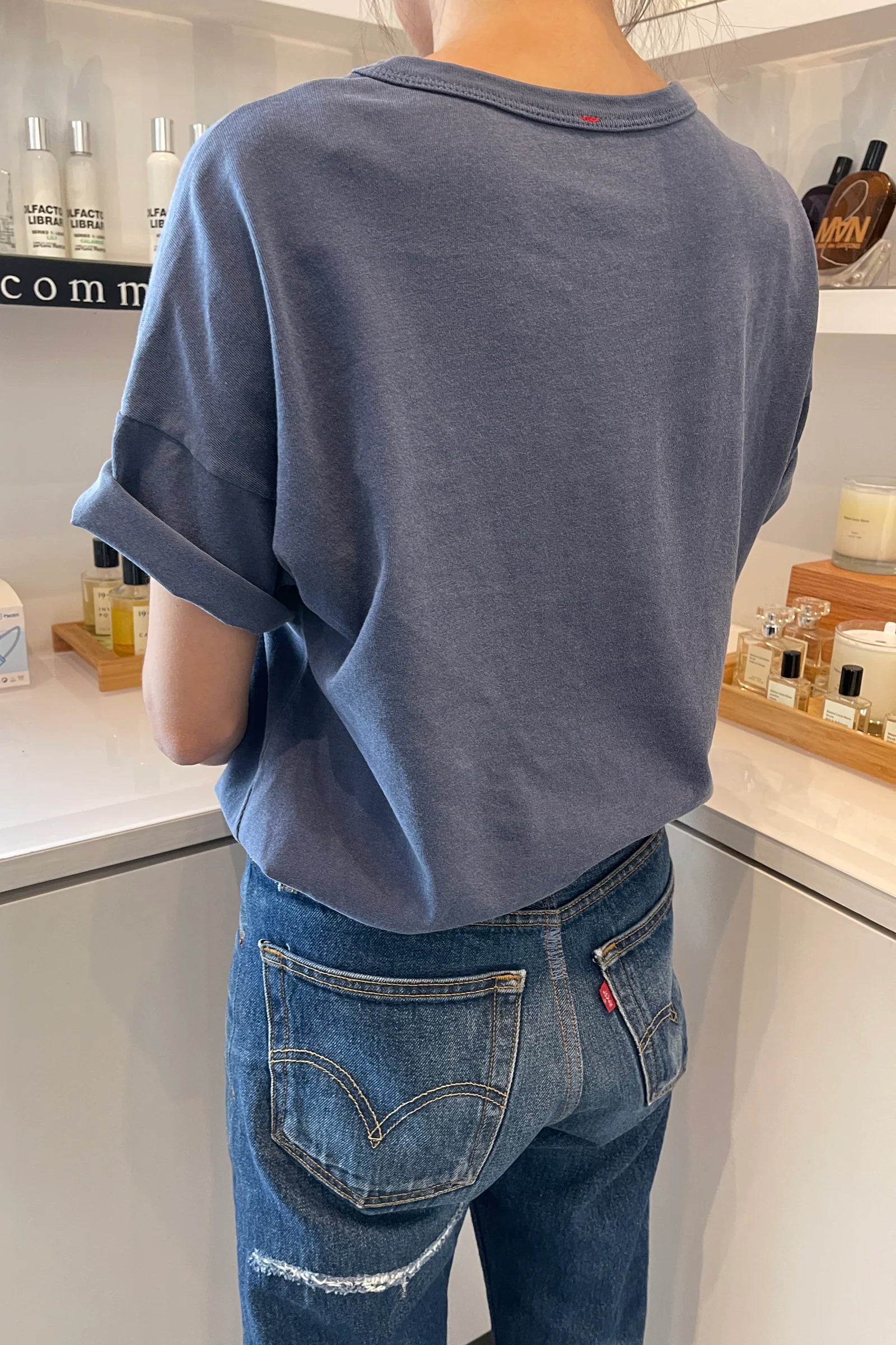 back of person wearing navy tee shirt and blue jeans