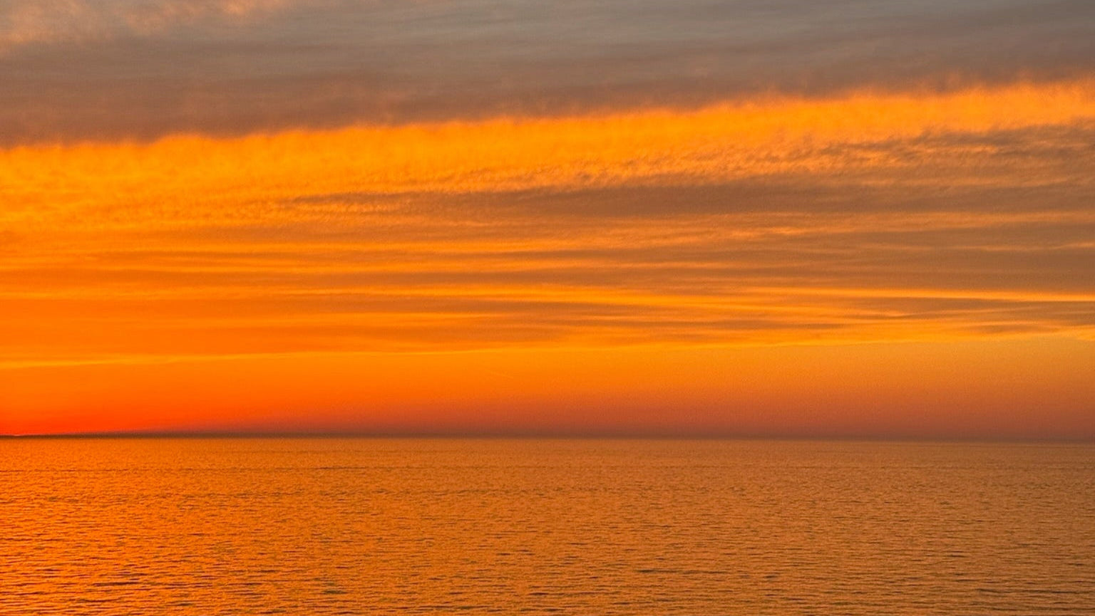 Sunset over water with orange and purple hues