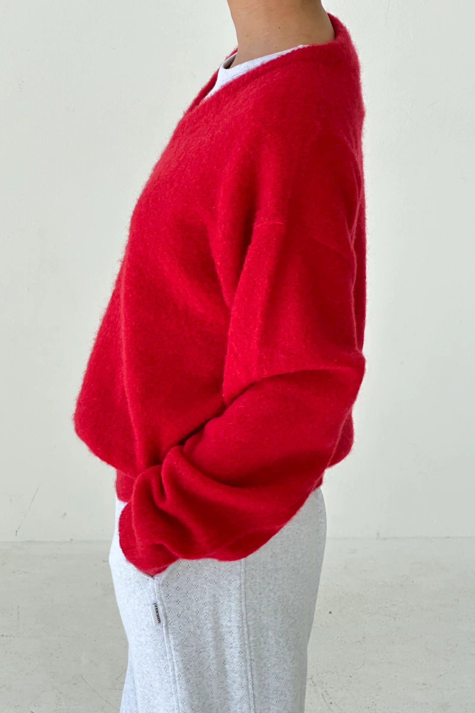 Red sweater worn by a person on a plain background