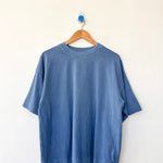 Blue t-shirt on a wooden hanger against a white background