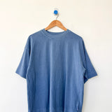 Blue t-shirt on a wooden hanger against a white background