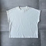 White sleeveless shirt on a gray tiled floor