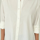 White button-up shirt worn by a person on a plain background