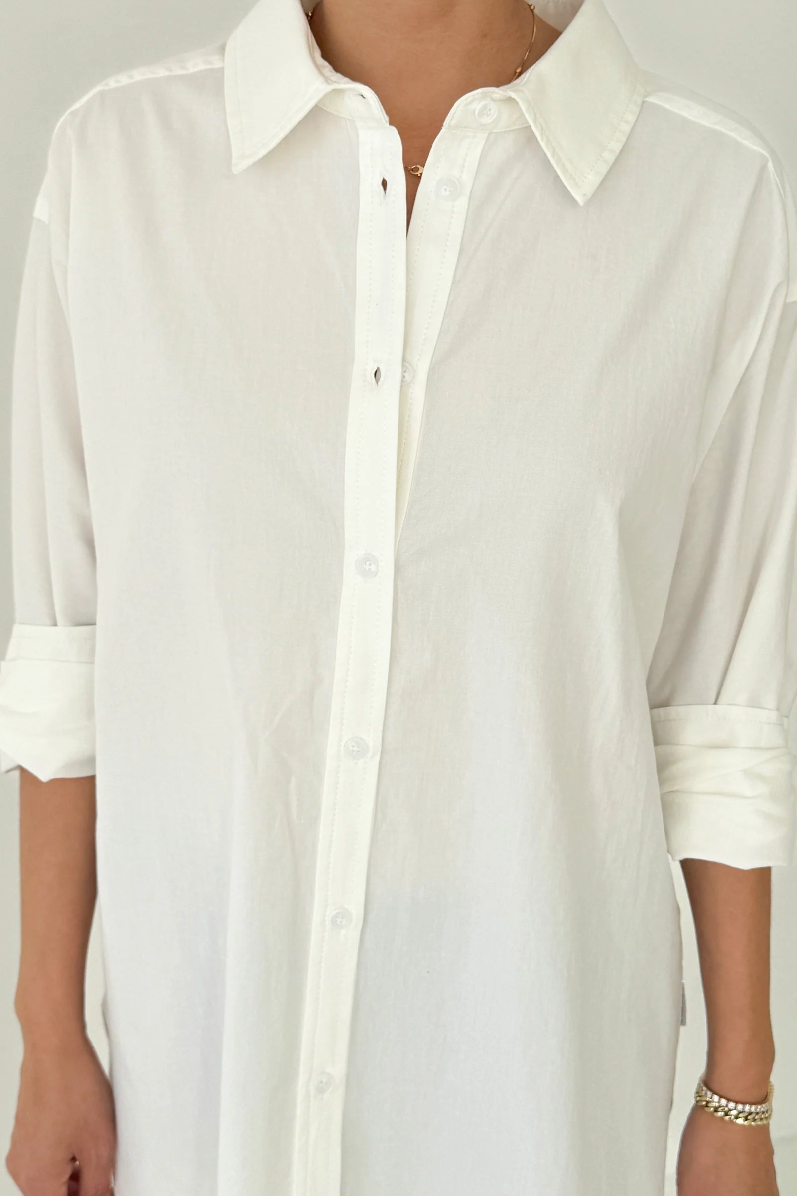 White button-up shirt worn by a person on a plain background
