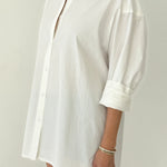 White shirt worn by a person on a plain background