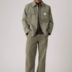 Man wearing a green jacket and pants on a plain background