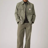 Man wearing a green jacket and pants on a plain background