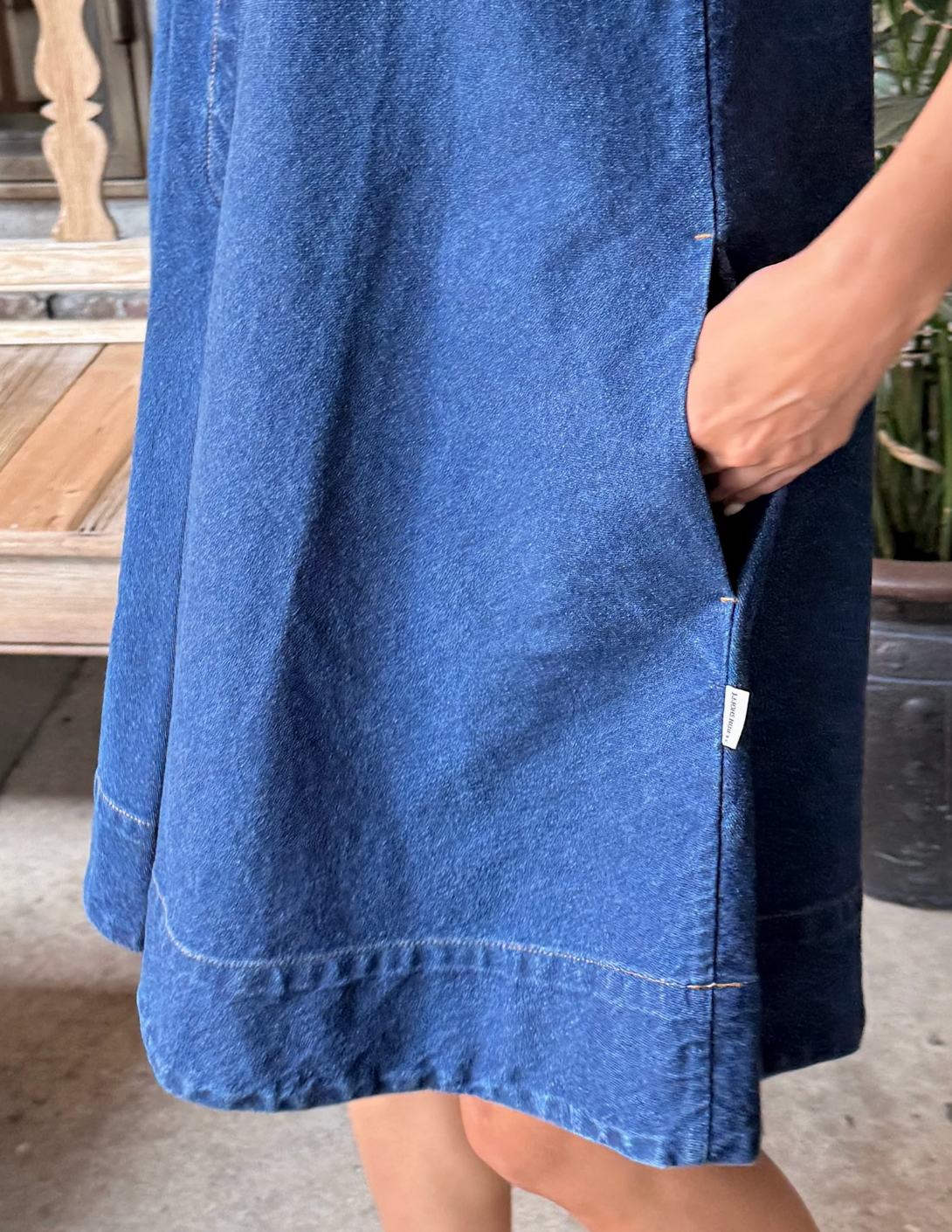 Blue denim dress worn by a person with a blurred background