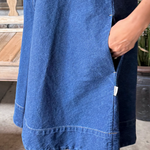 Blue denim dress worn by a person with a blurred background