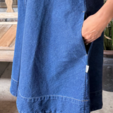 Blue denim dress worn by a person with a blurred background