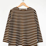 Brown and white striped shirt on a hanger against a white background