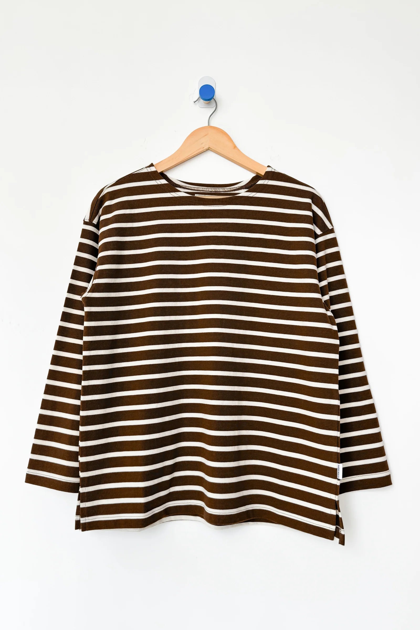 Brown and white striped shirt on a hanger against a white background
