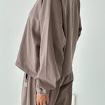 Person wearing a brown outfit against a white background