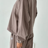 Person wearing a brown outfit against a white background