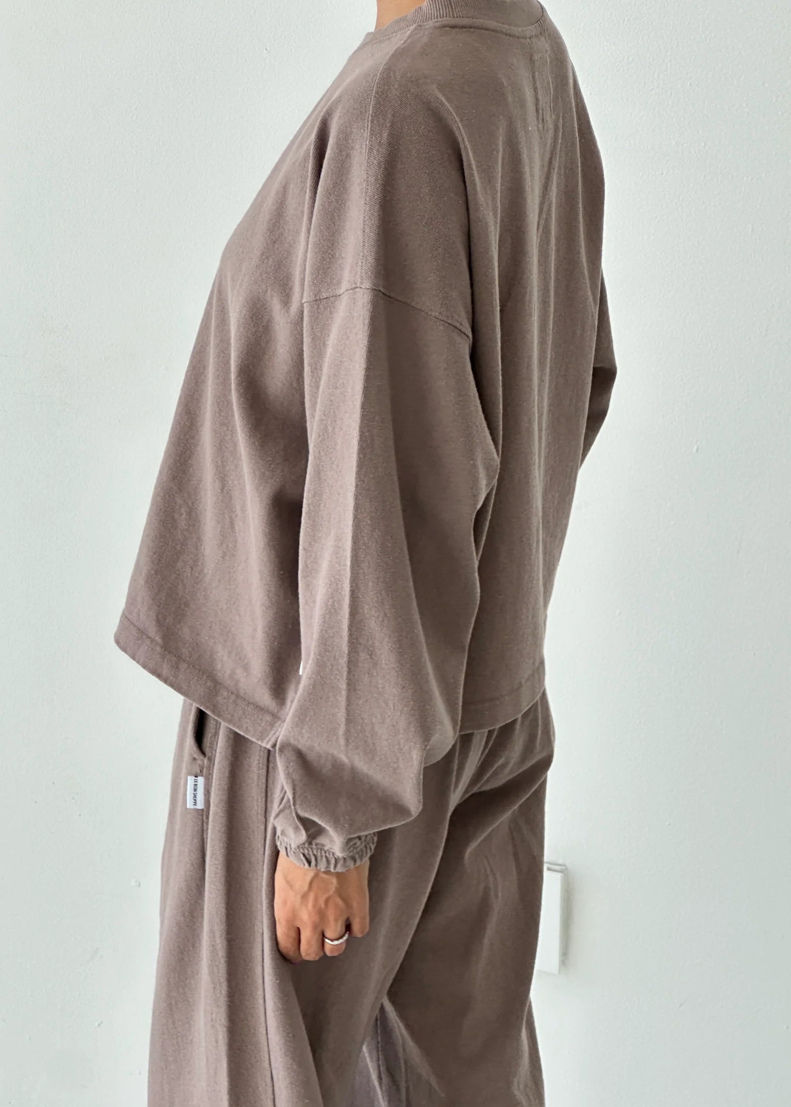 Person wearing a brown outfit against a white background