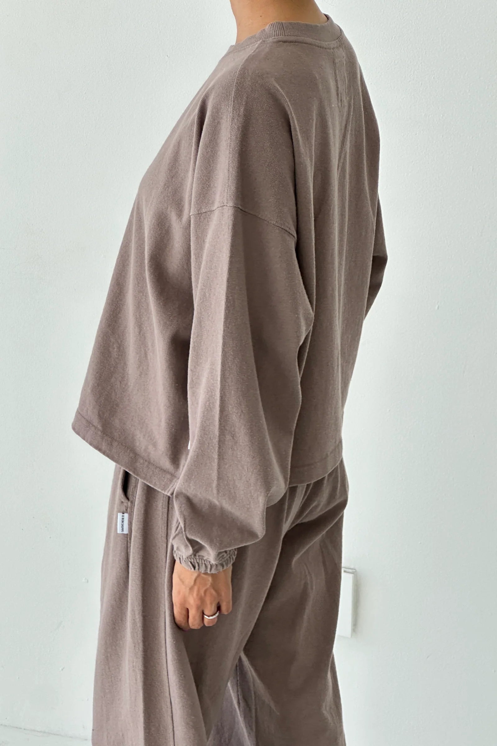 Person wearing a brown outfit against a white background