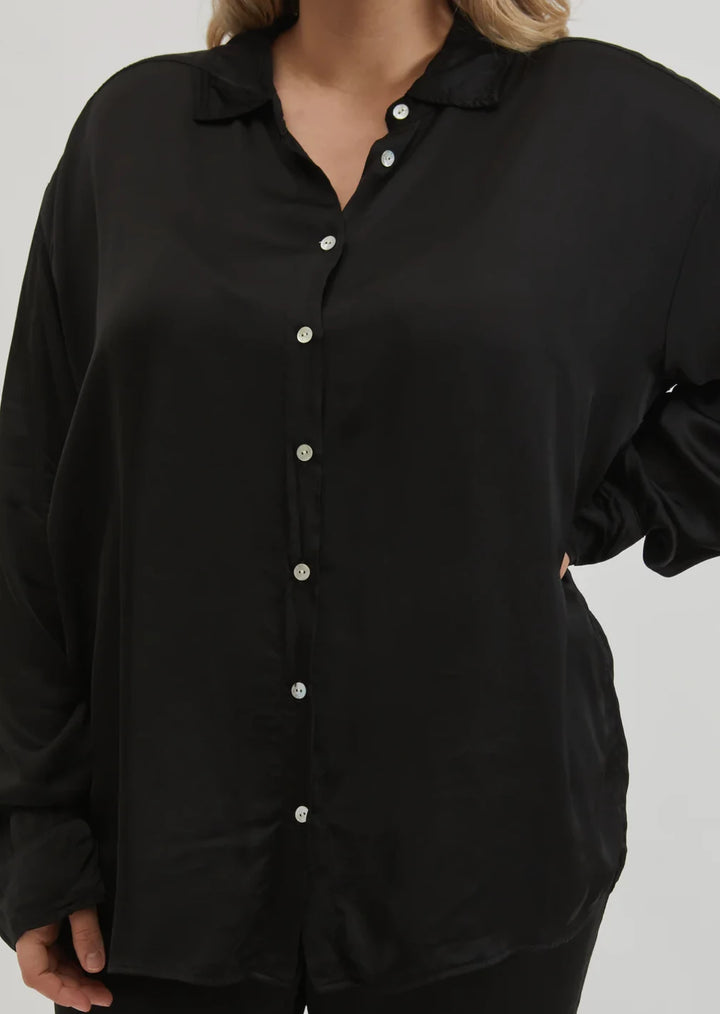 A close up image of the front of the Jet Silky Blouse on a female model 
