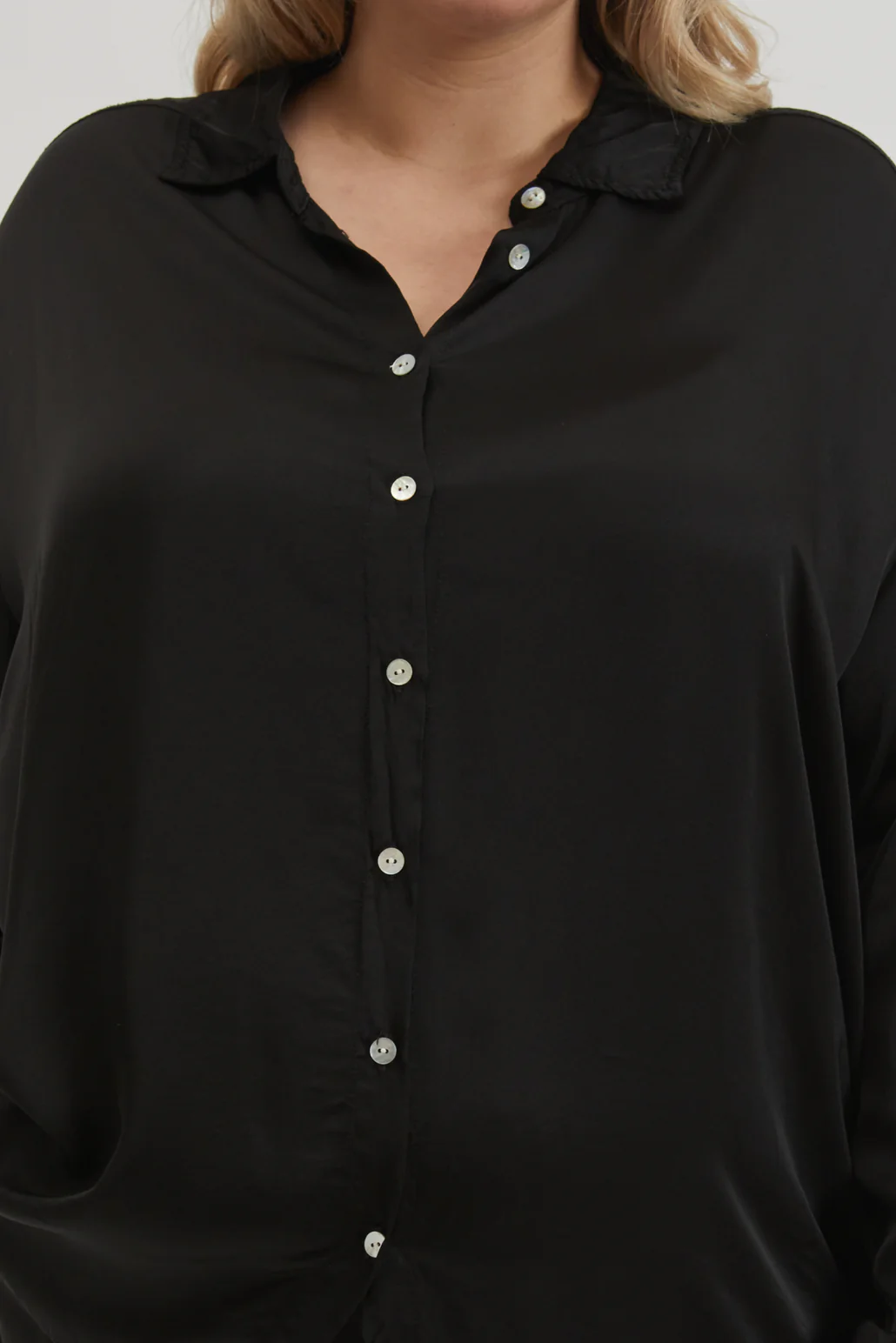 A very close up image of the button front detail of the Jet Silky Shirt on a female model