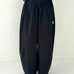 Person wearing black wide-leg pants on a white background