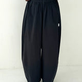 Person wearing black wide-leg pants on a white background