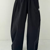 Person wearing black wide-leg pants on a white background
