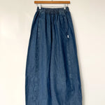 Blue denim skirt on a hanger against a white background