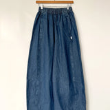 Blue denim skirt on a hanger against a white background