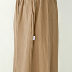 Beige pants with a white tag on a plain background