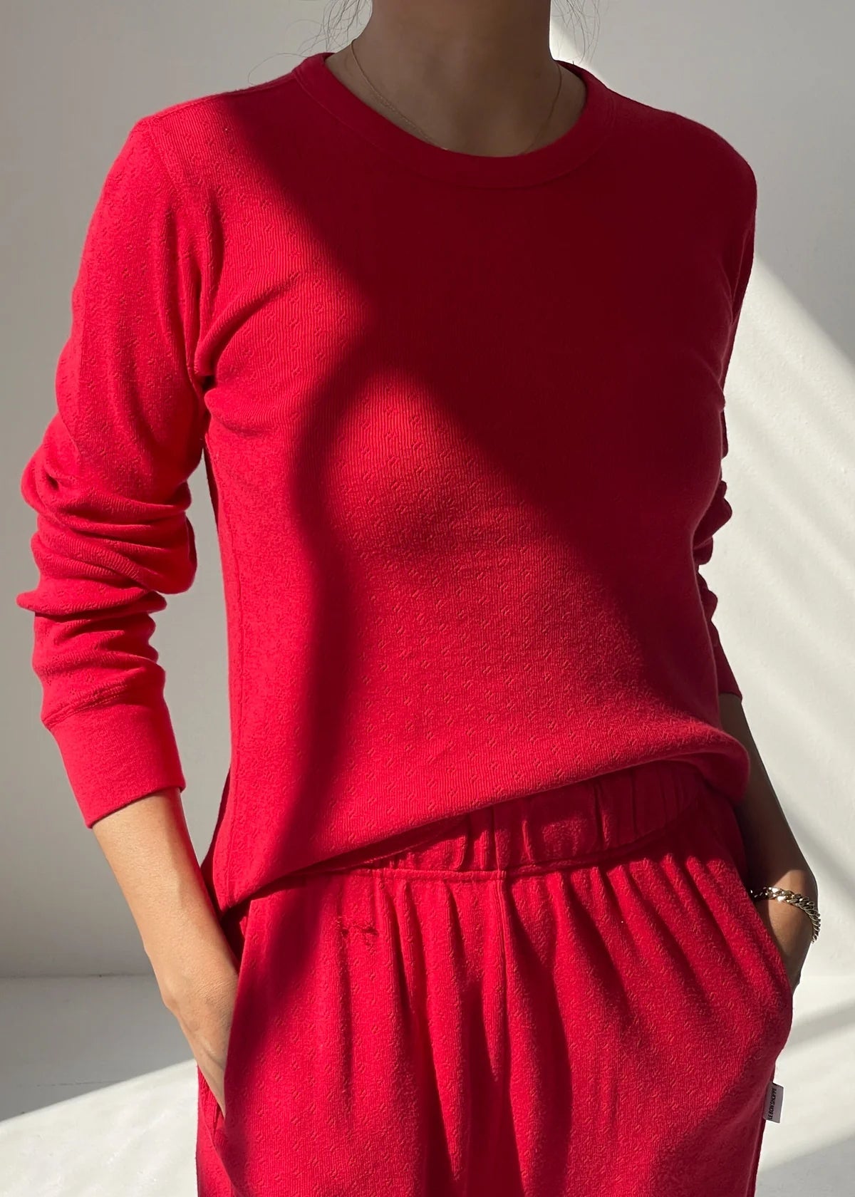 Person wearing a red outfit with a plain background