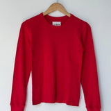 Red sweater on a hanger against a white background