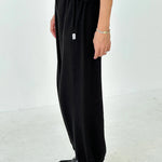 Person wearing black pants and shoes on a white background