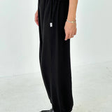 Person wearing black pants and shoes on a white background