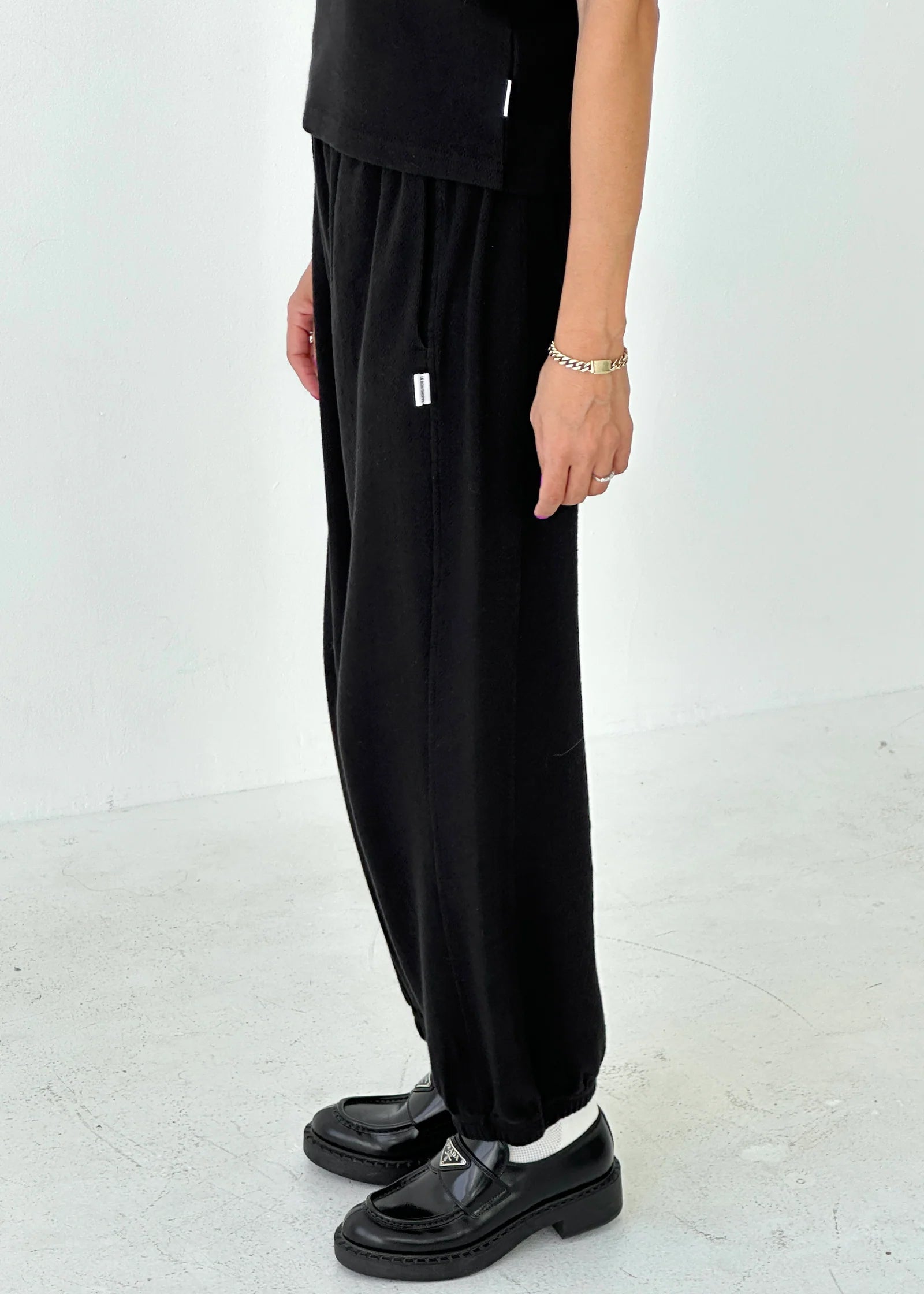 Person wearing black pants and shoes on a white background