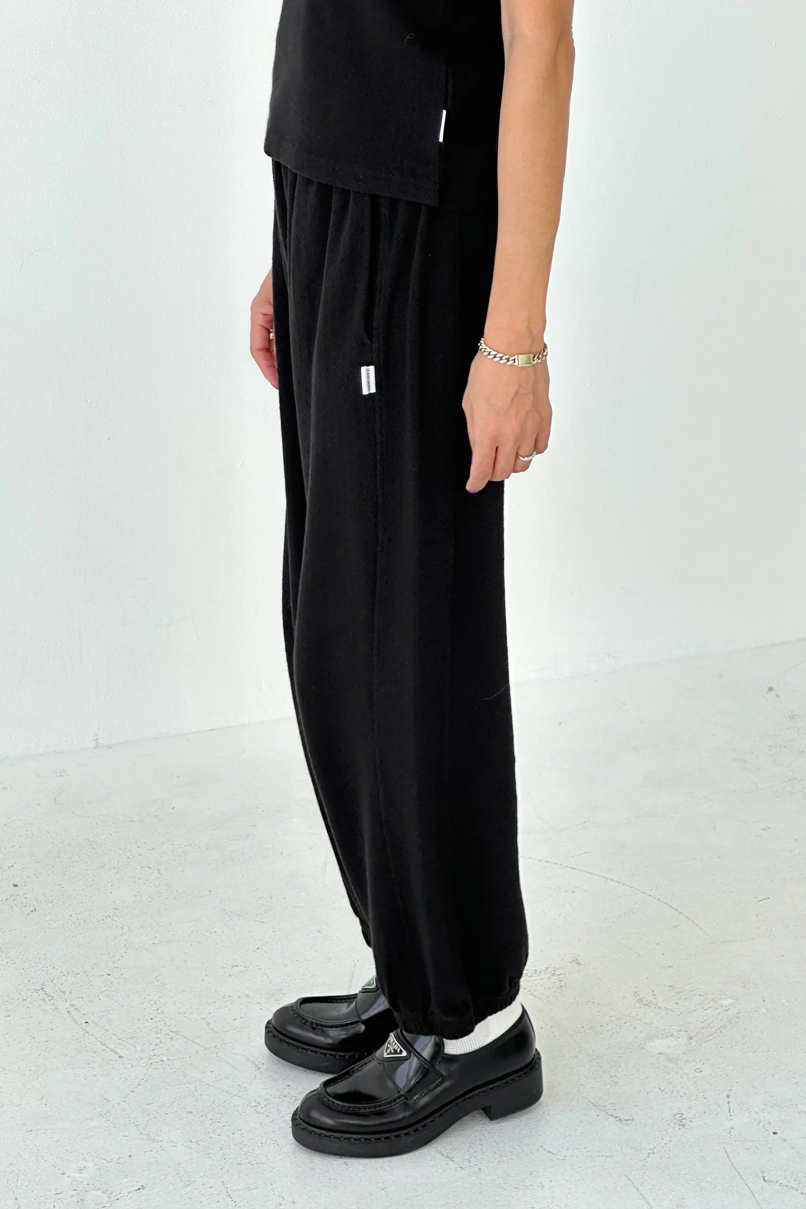 Person wearing black pants and shoes on a white background